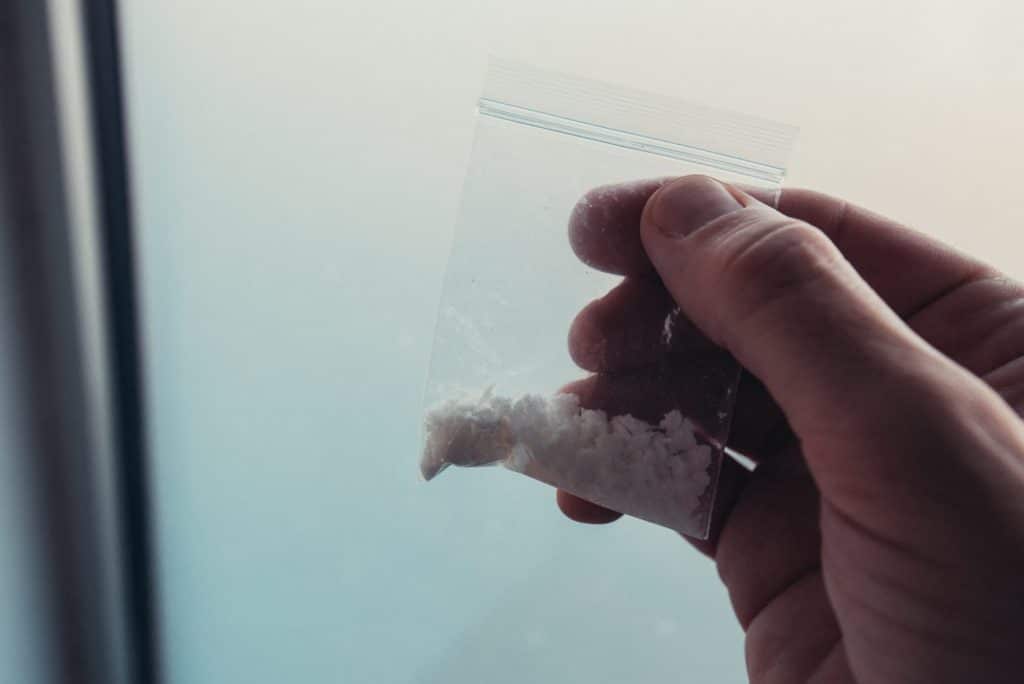 Criminology expert collecting drug evidence at crime scene