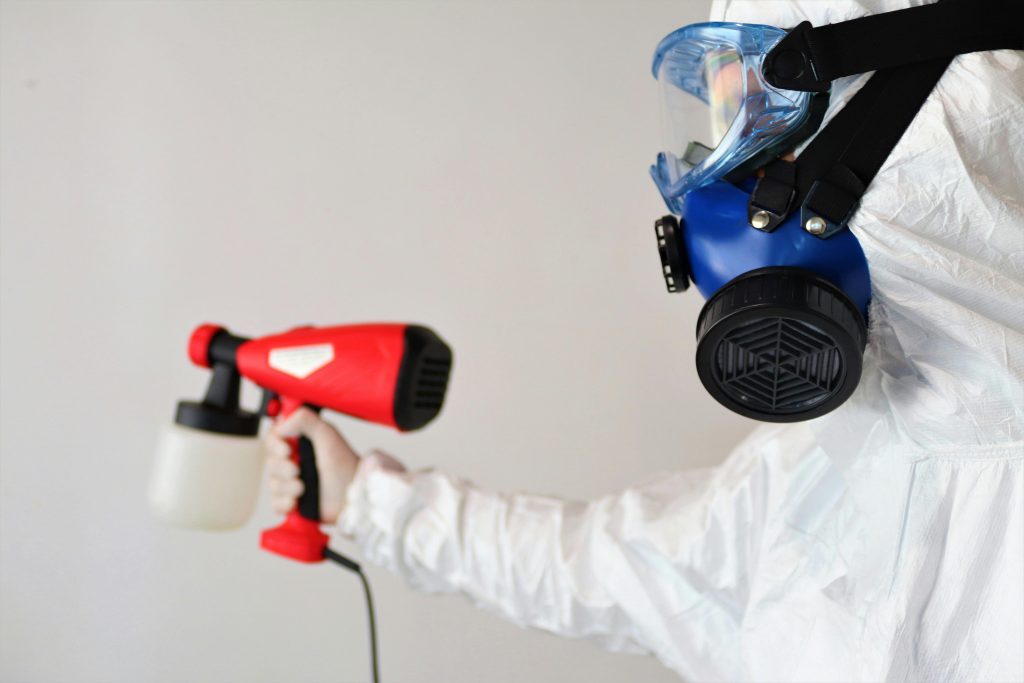 Person using a spray gun with a mask