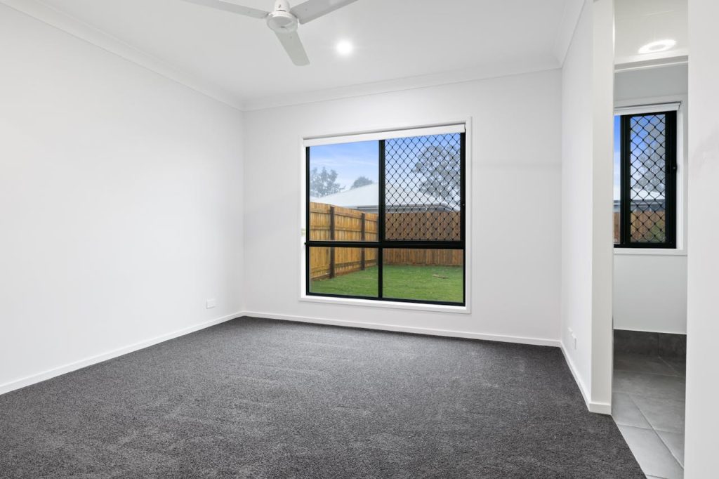 Spacious room with window and fresh carpet.